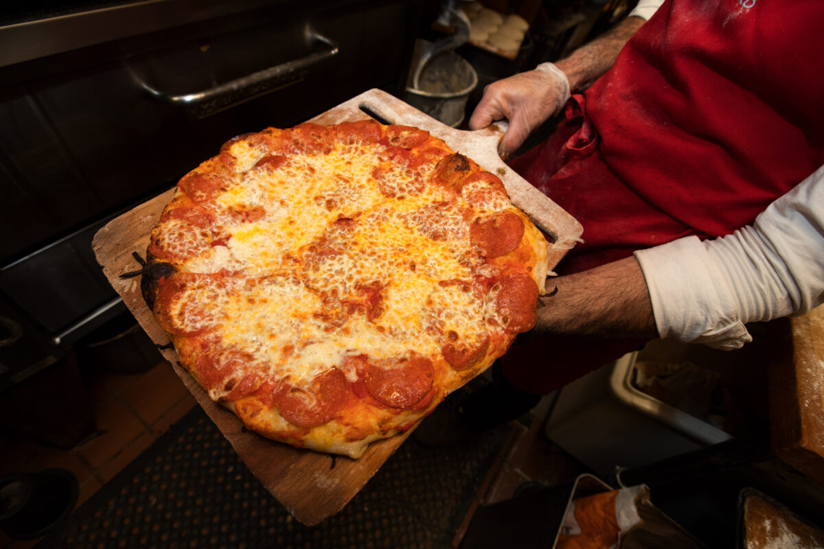 A freshly made pizza is pulled out of the oven, during community pizza night with live music at Raymond's Bakery, in Cazadero, Calif., on Friday, May 13, 2022. (Photo by Darryl Bush / For The Press Democrat)