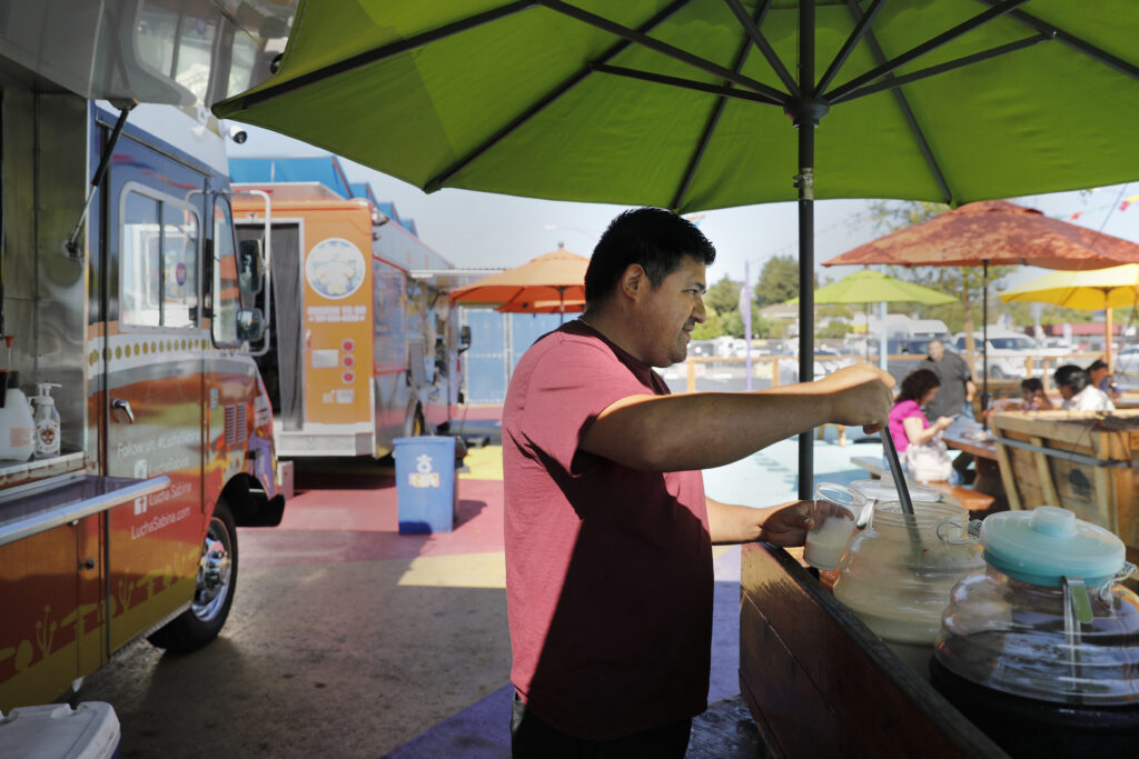 Damian Zuniga, owner of Lucha Sabina food truck, fills a glass of Horchata at the Mitote Food Park in Santa Rosa, Calif. on Monday, July 25, 2022. (Beth Schlanker/The Press Democrat)