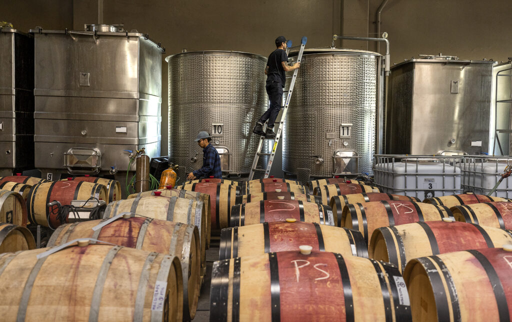 Monte Rio Cellars owner/winemaker Patrick Cappiello, right, and assistant Jesus Aleman stir blended Monte Rio Cellars wine in a tank in the Pax Wines' winemaking facility at The Barlow in Sebastopol. (John Burgess/Sonoma Magazine)