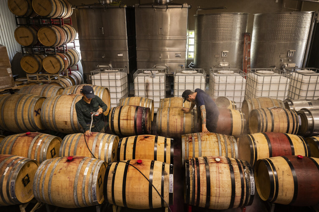 Monte Rio Cellars owner/winemaker Patrick Cappiello, right, and assistant Jesus Aleman pump over wine before filtering and bottling in the Pax Wines' winemaking facility at The Barlow in Sebastopol. (John Burgess/Sonoma Magazine)