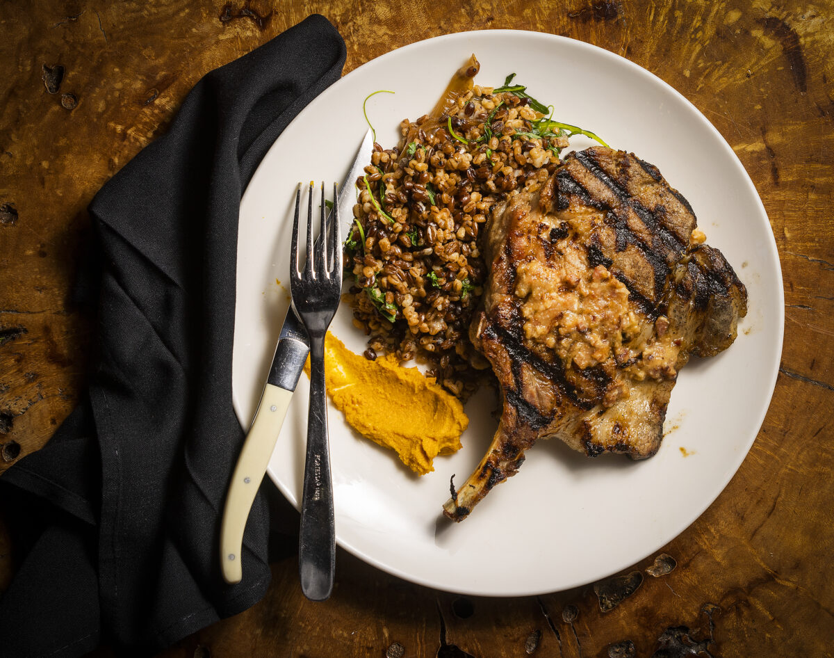 Heritage Pork Chop with smoked ginger puree, toasted grains, mustard greens and bacon apple compote from the Coast Kitchen at the Timber Cove Resort on the Sonoma Coast. (John Burgess/The Press Democrat)