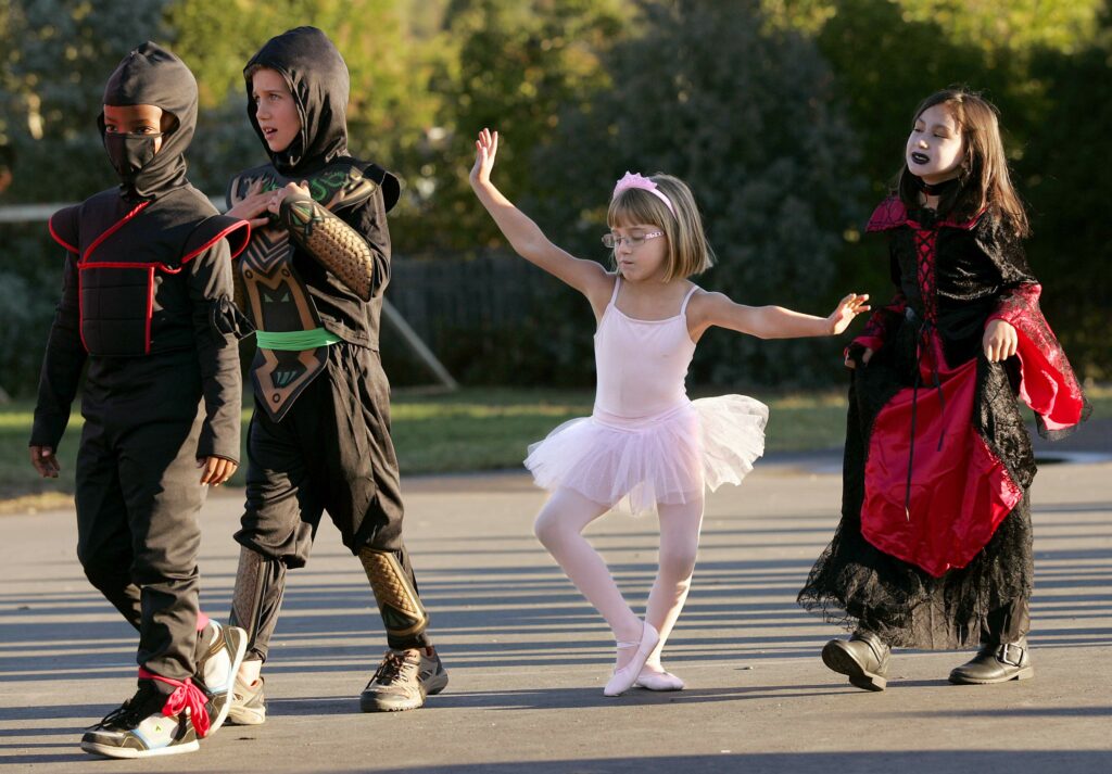 Dressed as a ballerina for Halloween, Spring Creek Elementary School student Lily Lee performs a plié while parading around campus with students, from left, Judah Keita, Kellen Goodfellow and Malaya Dela Concepcion, Friday October 30, 2015 in Santa Rosa. (Chad Surmick / The Press Democrat)