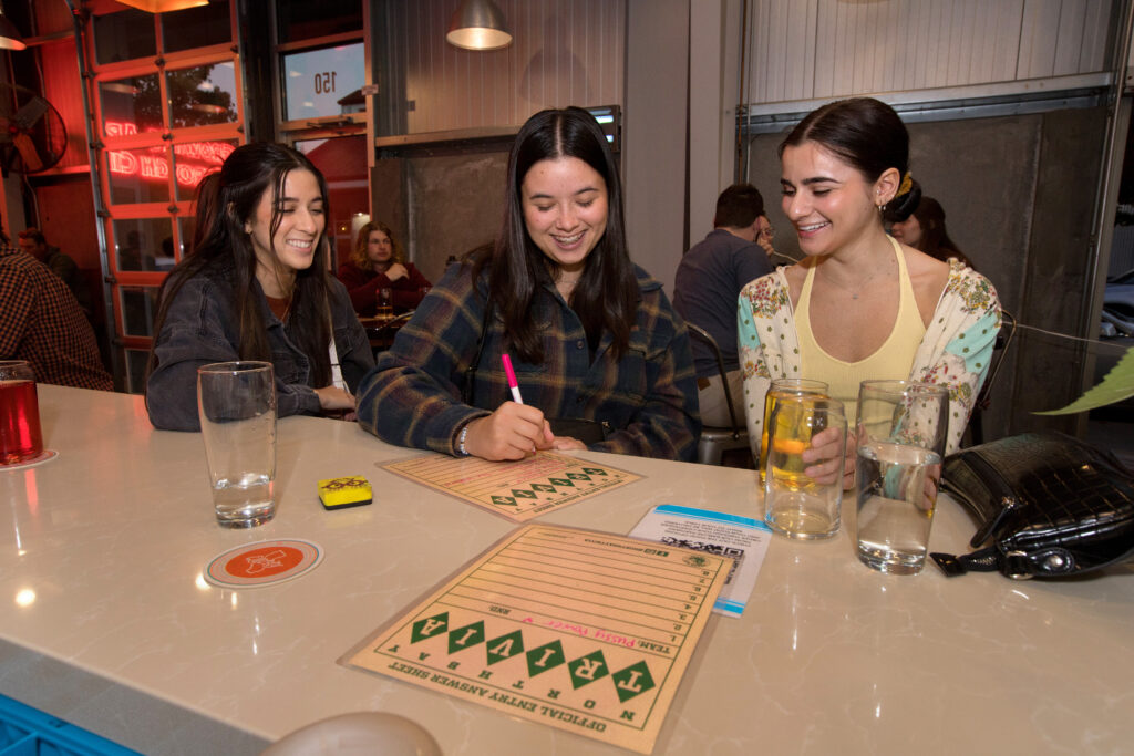 From left, Talia Putman, Audrianna Chappell, and Alexa Kolintzas, all of Rohnert Park, answer trivia questions during trivia night presented by North Bay Trivia at Golden State Cider Taproom, Thursday, October 13, 2022, in Sebastopol. (Darryl Bush / For The Press Democrat)