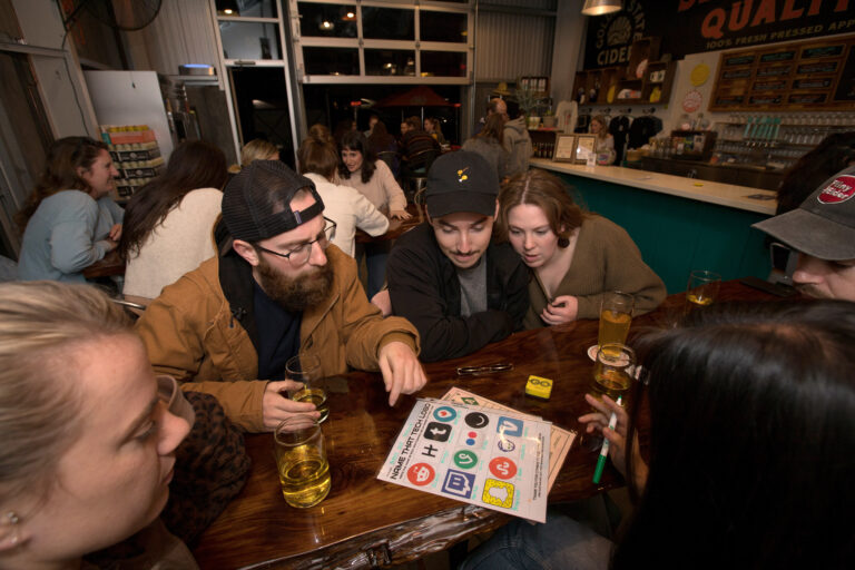 Left to right (center), Tanner Faber, Michael Estens, and Katie-Lauren Dunbar (hyphenated first name), all of Santa Rosa, calling themselves the team name "Bidets and Confused" discuss their answers to trivia questions during trivia night presented by North Bay Trivia at Golden State Cider Taproom, Thursday, October 13, 2022, in Sebastopol. (Darryl Bush / For The Press Democrat)