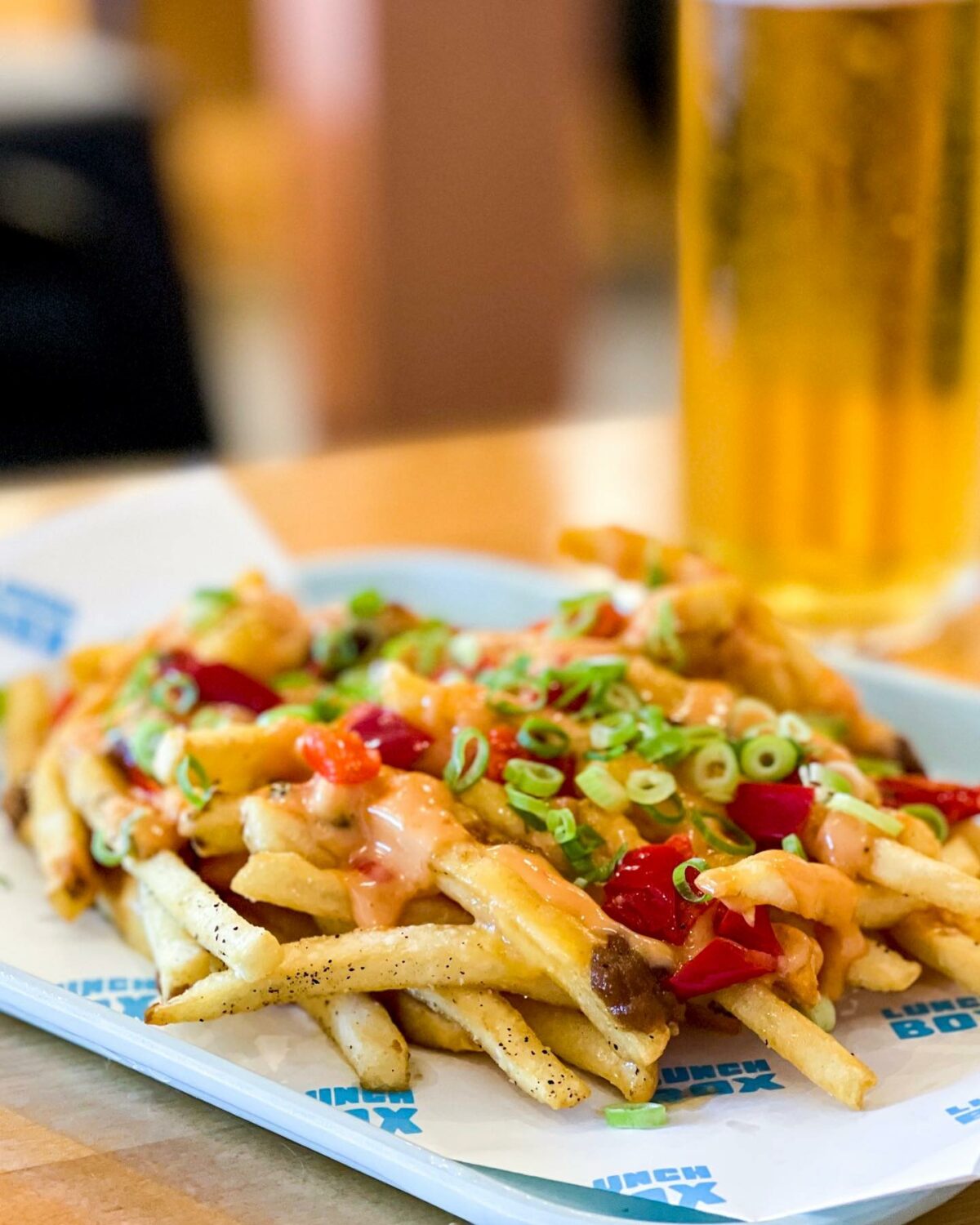 Crispy fries smothered in American cheddar, onion butter, fancy sauce, peppers and green onions. (Lunch Box)