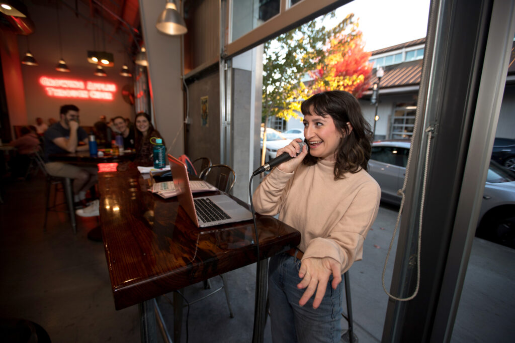 Emma Maidenberg of North Bay Trivia, talks to the audience during trivia night presented by North Bay Trivia at Golden State Cider Taproom, Thursday, October 13, 2022, in Sebastopol. (Darryl Bush / For The Press Democrat)