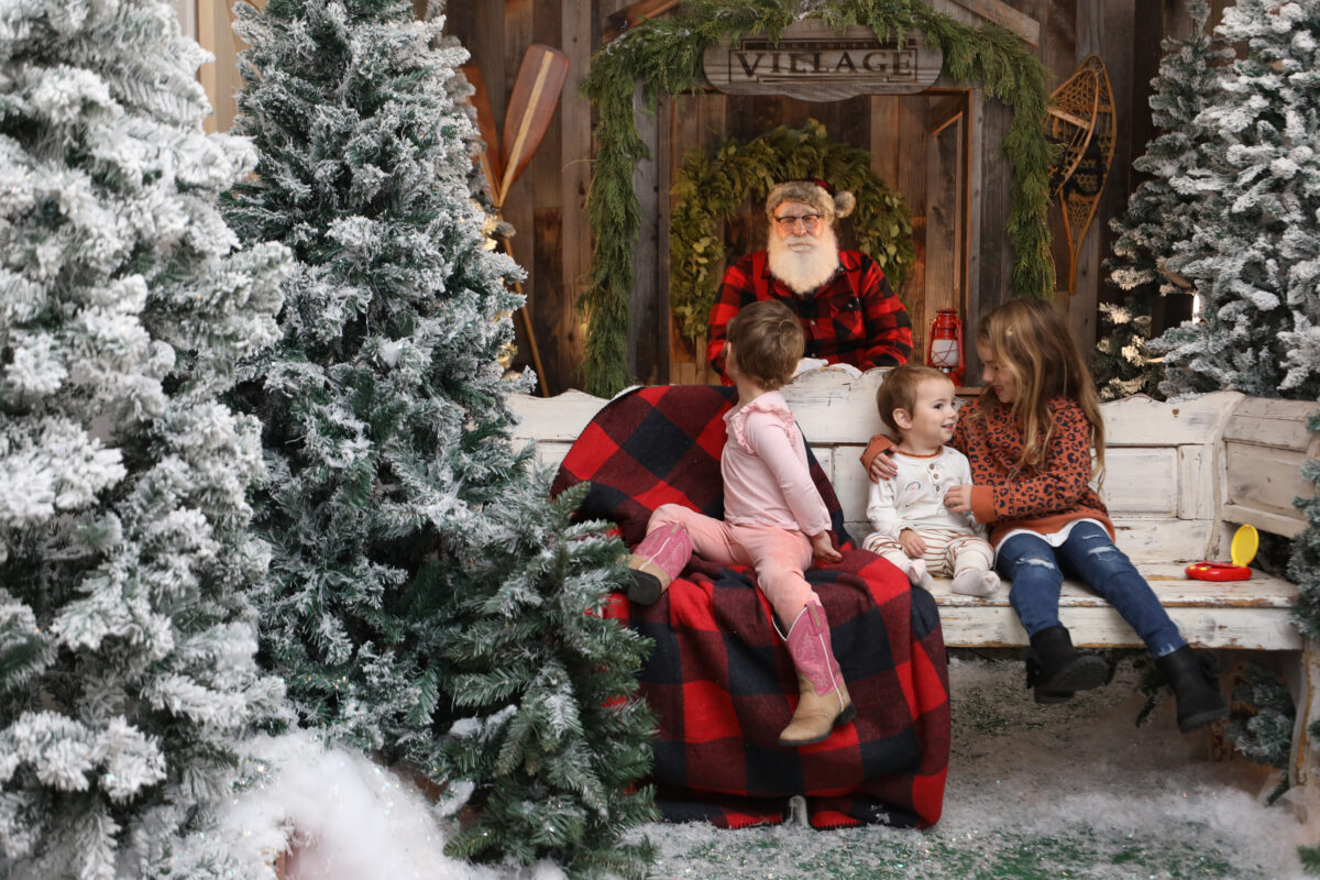 Santa Claus visits with sisters Aurora Grech, 3, left, Brynn 15-months-old, and Athena, 6, at Montgomery Village in Santa Rosa, Calif., on Sunday, December 5, 2021.(Beth Schlanker/The Press Democrat)