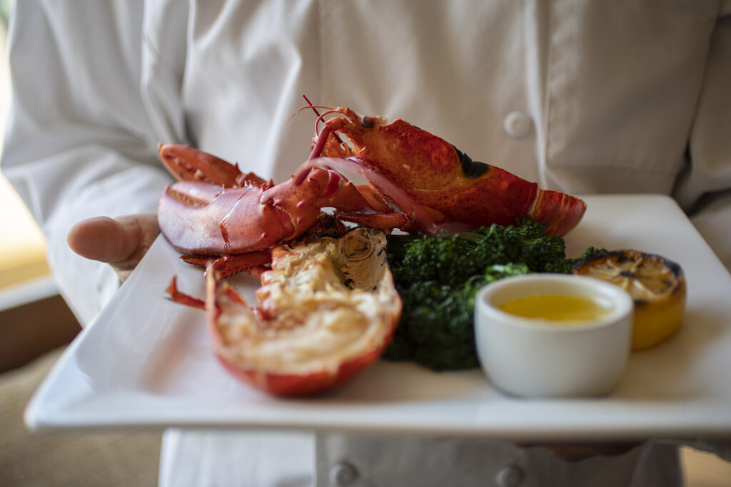 Chef Saul Razo holds his Grilled Main Lobster served with Broccolini and clear butter at Sonoma Grille in Sonoma on Friday February 4, 2022. (Chad Surmick / The Press Democrat)