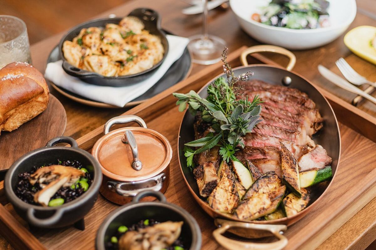 A holiday meal from Table Culture Provisions, featuring Cowboy Steak for Two, Maitake & Soy Beans Forbidden Black Rice; and Prawn Mac & Cheese. (Table Culture Provisions)