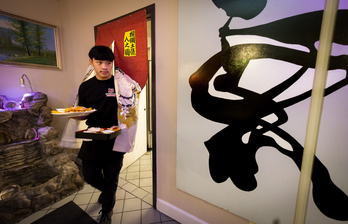Robert Phouthavong, 18, owner of Makizushi in Santa Rosa, delivers an order to customers Tuesday, January 3, 2023. Robert and his father Southavichit opened the restaurant after learning the business at Hana Sushi in Sebastopol. (John Burgess/The Press Democrat)