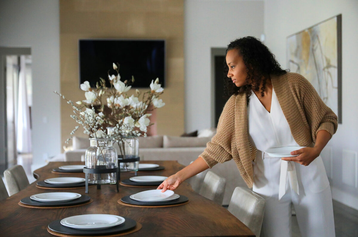Interior designer Stephanie Meyer arranges a table setting at a client's home in Santa Rosa on Friday, November 13, 2020. (Christopher Chung/The Press Democrat)