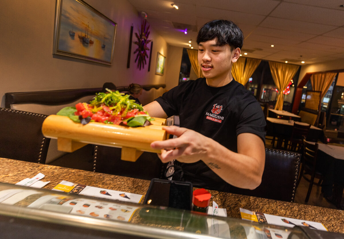 Robert Phouthavong, 18, owner of Makizushi in Santa Rosa, delivers an order to customers Tuesday, January 3, 2023. Robert and his father Southavichit opened the restaurant after learning the business at Hana Sushi in Sebastopol. (John Burgess/The Press Democrat)