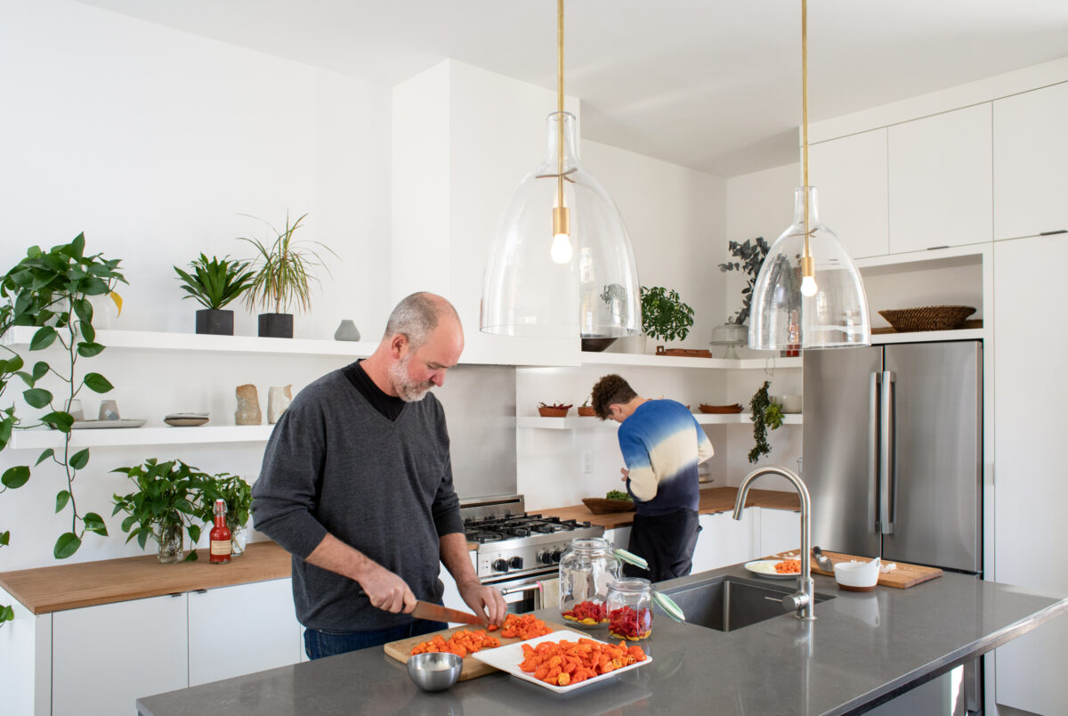 Danny Brennan, a computer engineer who has developed his own line of hot sauces, enjoys his kitchen island, the most popular spot in his remodeled Healdsburg cottage. (Eileen Roche)