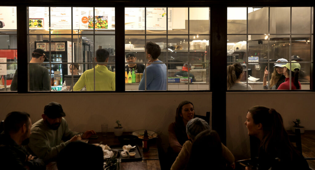 After finishing an evening run, participants of Healdsburg Running Co's run, order food at Lepe's Taqueria in Santa Rosa, Thursday, Feb. 9, 2023. (Kent Porter / The Press Democrat) 2023