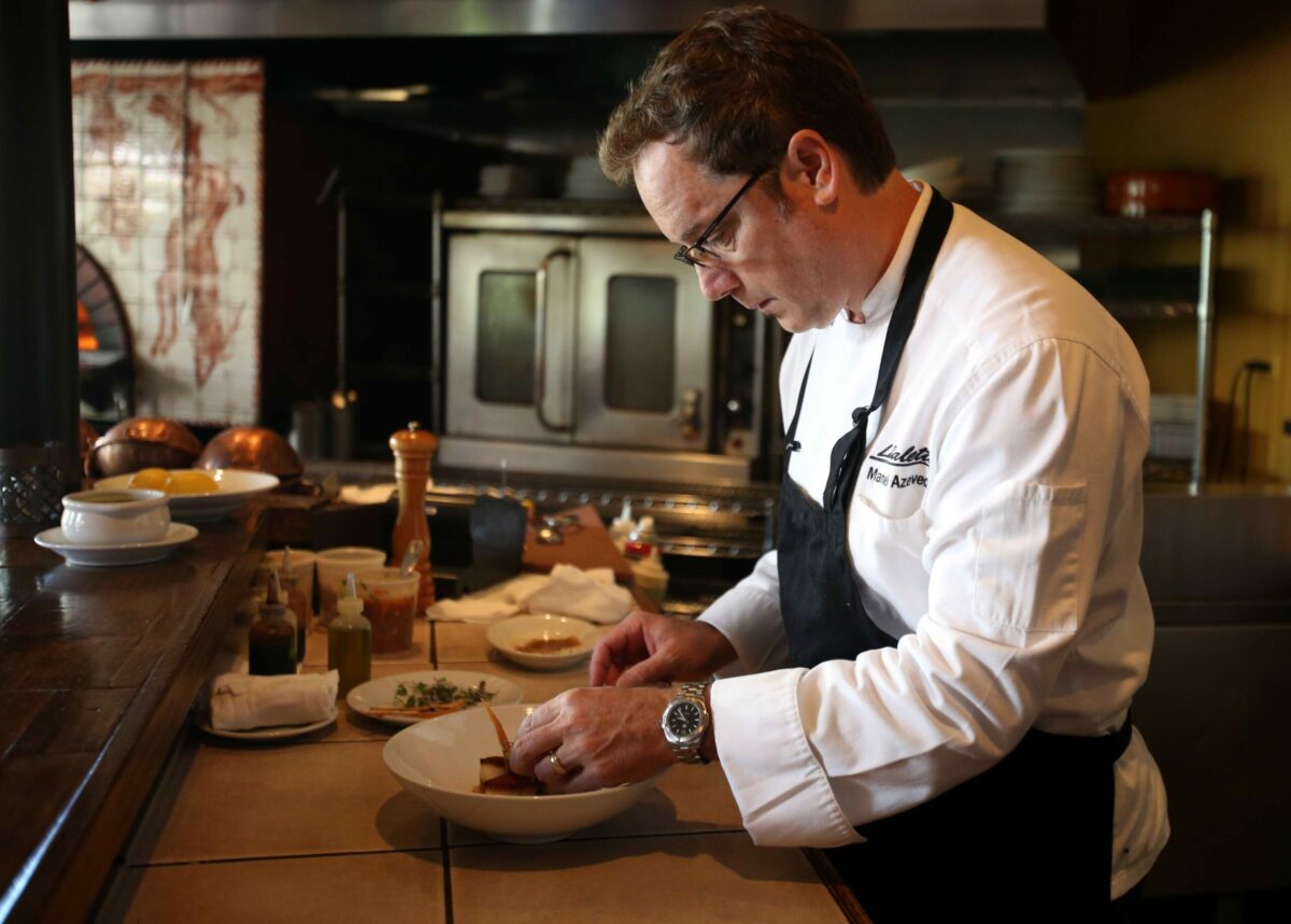 Executive chef/owner Manuel Azevedo prepares Chouriço Crusted Day Boat Scallops at LaSalette Restaurant in Sonoma, Thursday, Sept. 4, 2014. (Crista Jeremiason / The Press Democrat)
