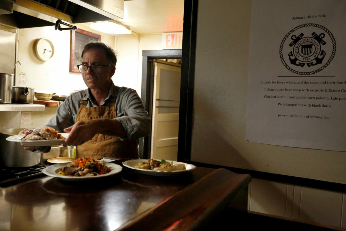 Casino Bar and Grill chef Mark Malicki prepares food for customers while offering a free dinner menu, at right, to Coast Guard members and their families, at Casino Bar and Grill in Bodega, California, on Friday, January 18, 2019. (Alvin Jornada / The Press Democrat)