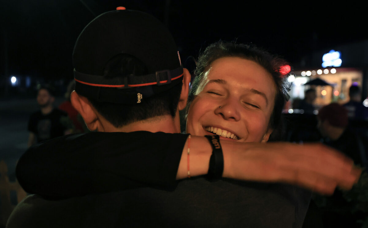 Sadie Alloway greets Matthew after finishing a night time run as part of Healdsburg Running Co's run and a meal afterward at Lepe's Taqueria in Santa Rosa, Thursday, Feb. 9, 2023. Both runners are from Sebastopol. (Kent Porter / The Press Democrat) 2023