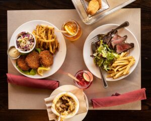 Crab Cakes and Seared Steak with sides from the new dinner menu at Americana in Santa Rosa April 13, 2023. (John Burgess/The Press Democrat)