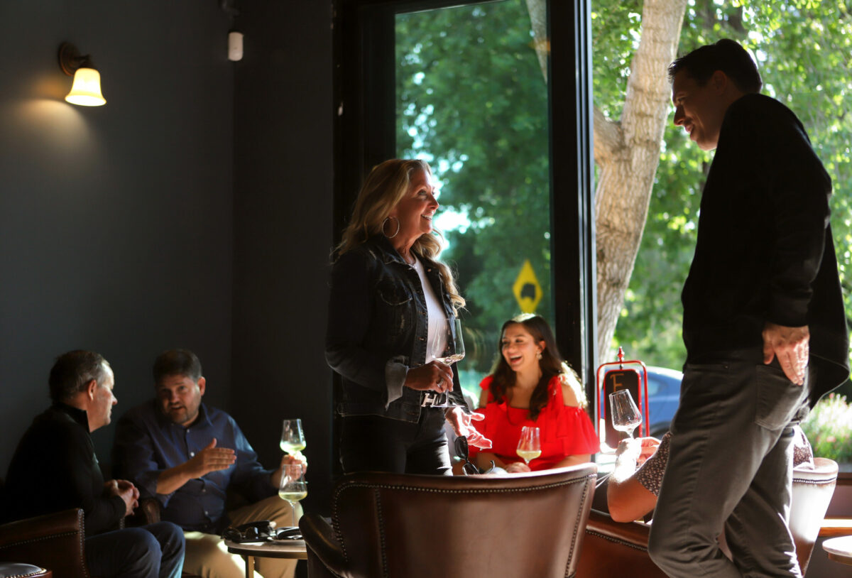Co-owner Evan Hufford, right, talks with customer Julie Keeley of St. Louis, Missouri, as others enjoy wine at Maison Wine Bar in Healdsburg, Friday, June 23, 2023. (Darryl Bush / For The Press Democrat)