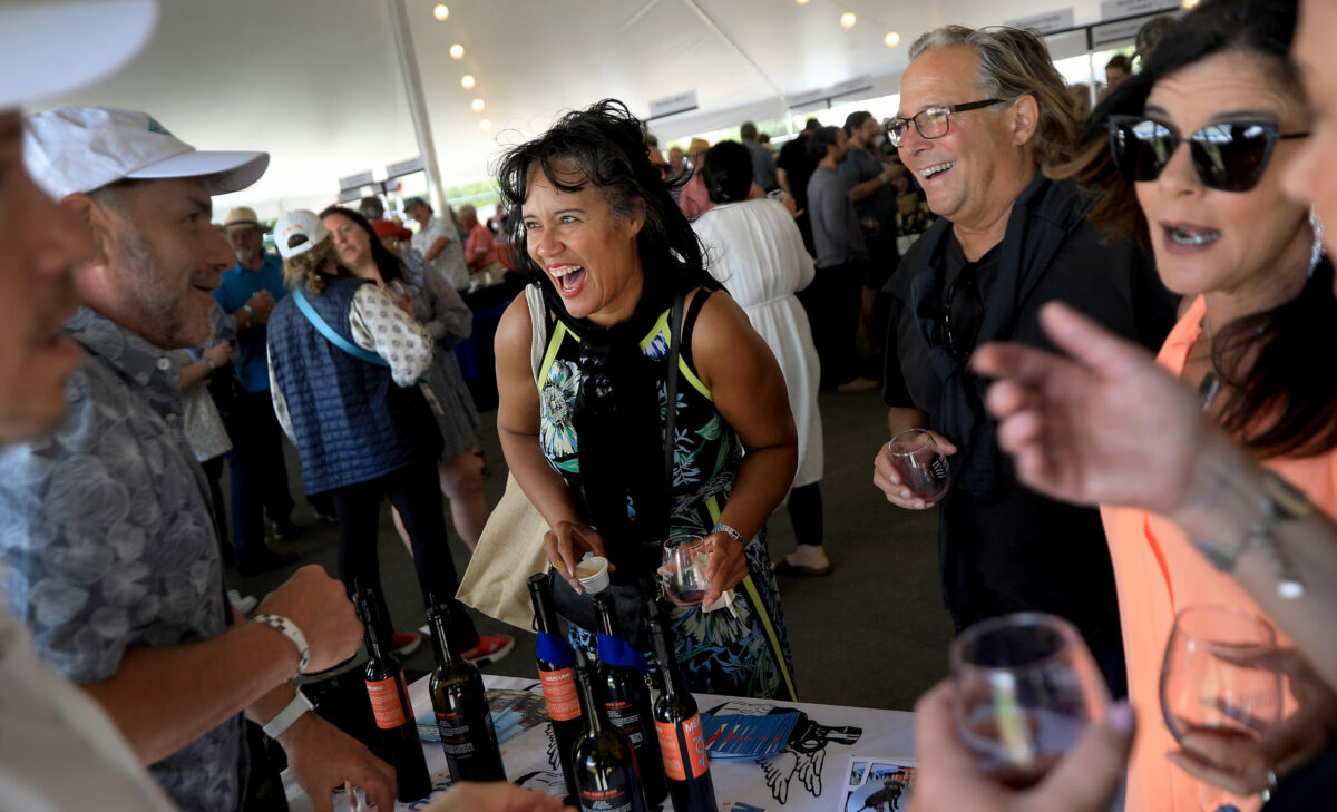 From left, clockwise, Daniel Fox and Brad Beard of Mercury Wines of Healdsburg, have animated conversations with Santa Rosa residents Toni Navy, Gary Marsh, Tanya Rabellino and April Voss during the North Coast Wine and Food Festival at the Luther Burbank Center for the Arts in Santa Rosa, Saturday, June 18, 2022. (Kent Porter / The Press Democrat) 2022