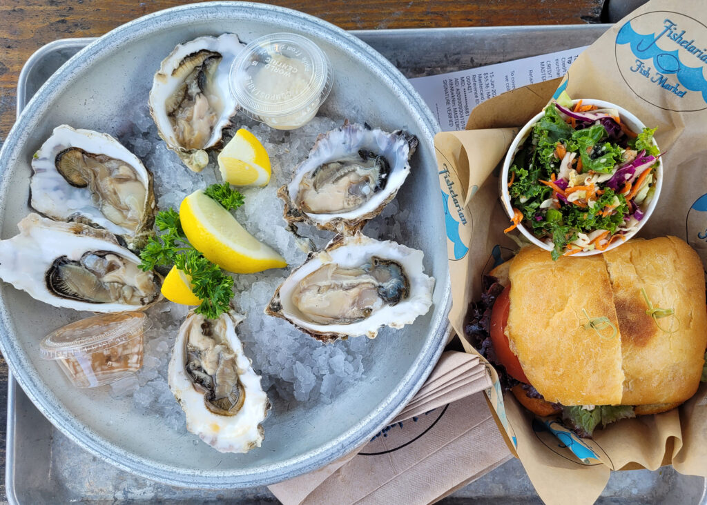 Raw oysters and a crab sandwich with kale slaw at Fishetarian Fish Market in Bodega Bay. (Heather Irwin / The Press Democrat)