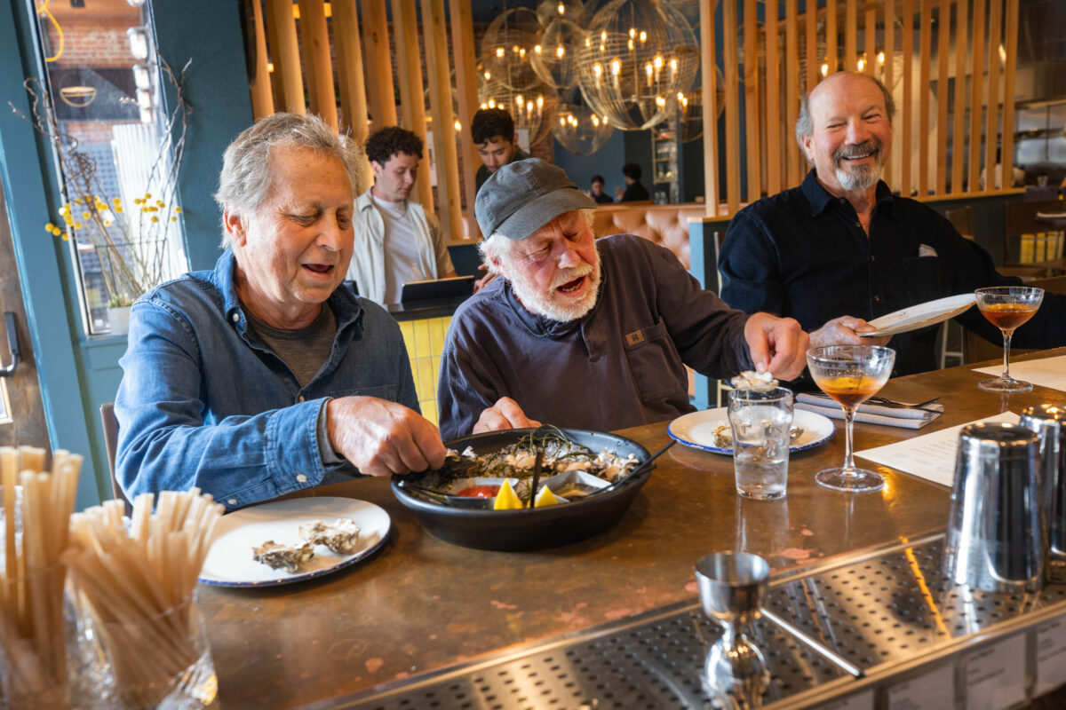 From left, Richard Wagner, Bernie Izzarelli and Michael Skurtun share a plate of oysters at the Goldfinch bar Wednesday, May 24, 2023, in Sebastopol. (John Burgess/The Press Democrat)