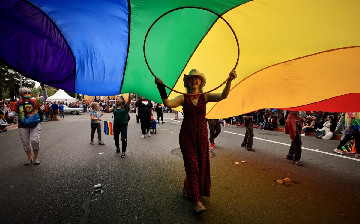 Jen Bredesen from Sebastopol supports the middle of a large rainbow flag during the Sonoma County Pride Parade and Festival in downtown Santa Rosa, Saturday, June 4, 2022. The flag was part of the Community Church of Sebastopol entry. (Kent Porter / The Press Democrat) 2022