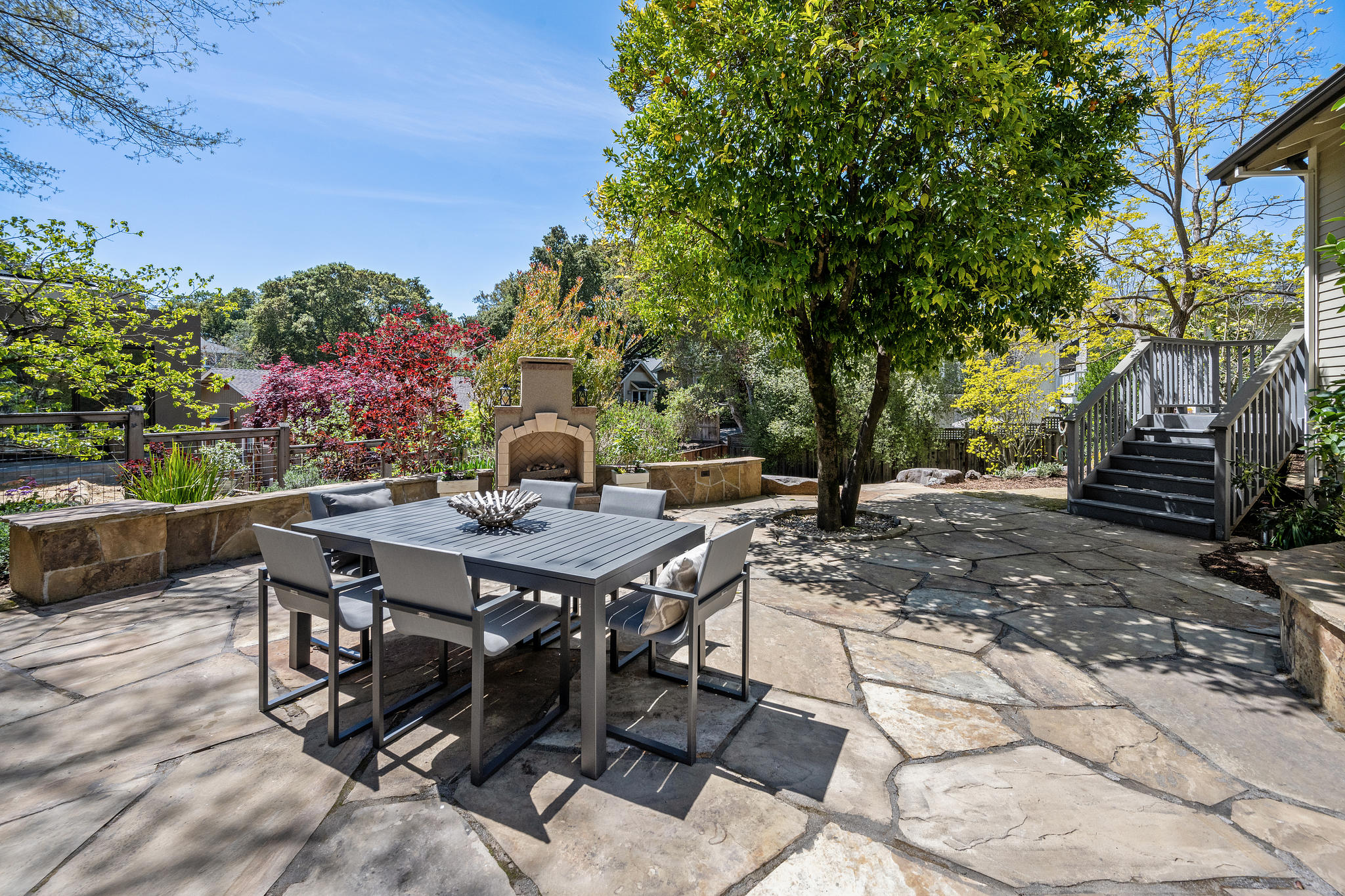 An outdoor fireplace provides the warmth and a mature citrus tree provides the shade to this patio. (Open Homes Photography)