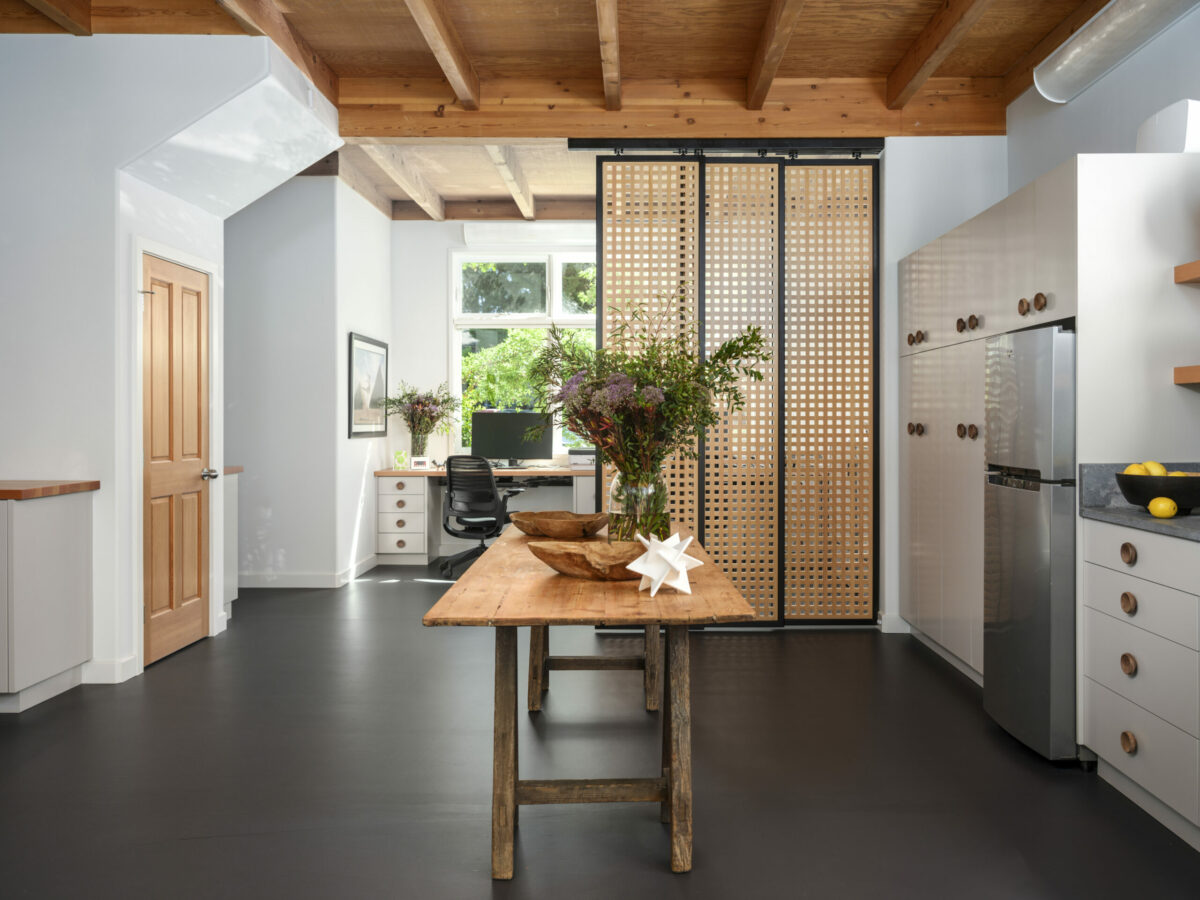 A custom sliding screen closes off the work area from the kitchen. The wood grid lets light to pass through allow the barrier a sense of openness. (Christopher Stark)
