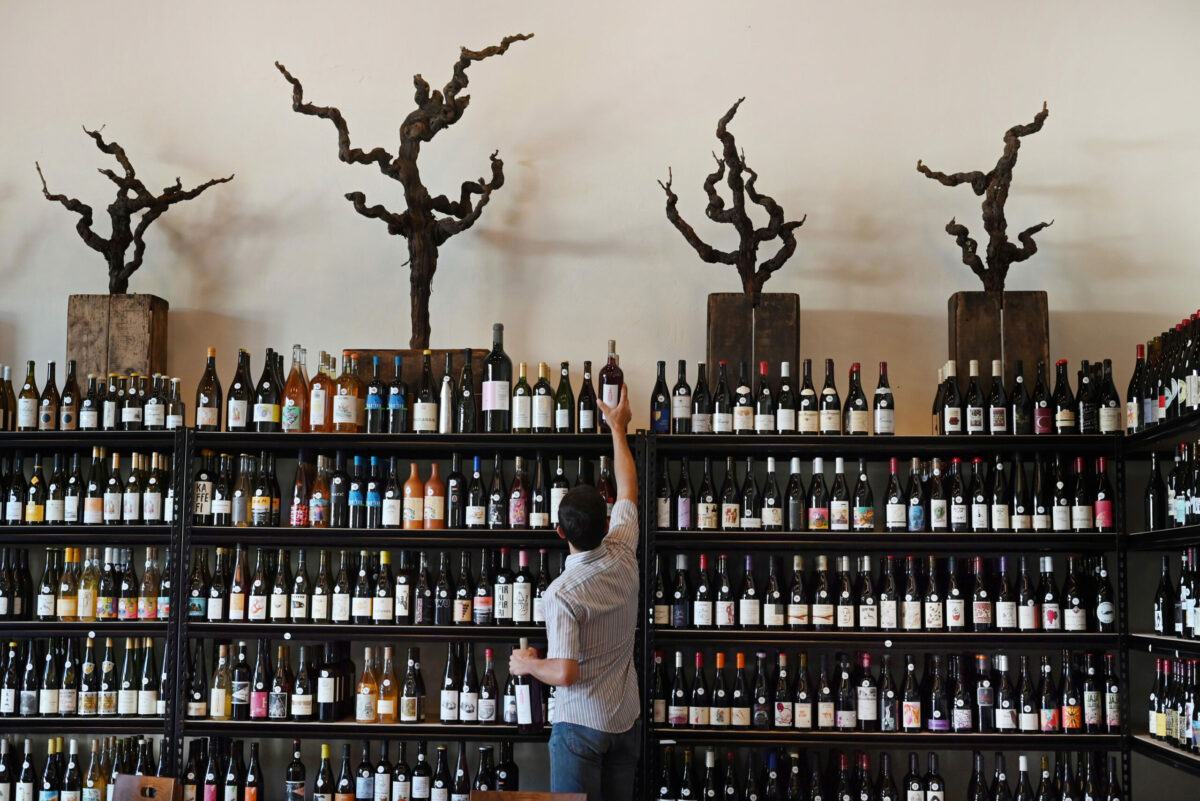 Wesley Hammond stocking up rows of natural wines at The Punchdown Natural Wine Bar + Bottle Shop during a friends and family soft opening on Friday, May 12, 2023 in the Barlow in Sebastopol. (Erik Castro / For The Press Democrat)