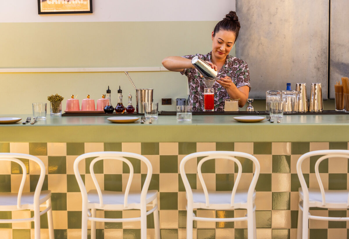 Danielle Peters makes a Capriccio with Gin, Aquavit, Tomato Water, Lemon, Caperberry and S&P Bitters behind the bar at Molti Amici in Healdsburg Wednesday, July 19, 2023. (John Burgess/The Press Democrat)