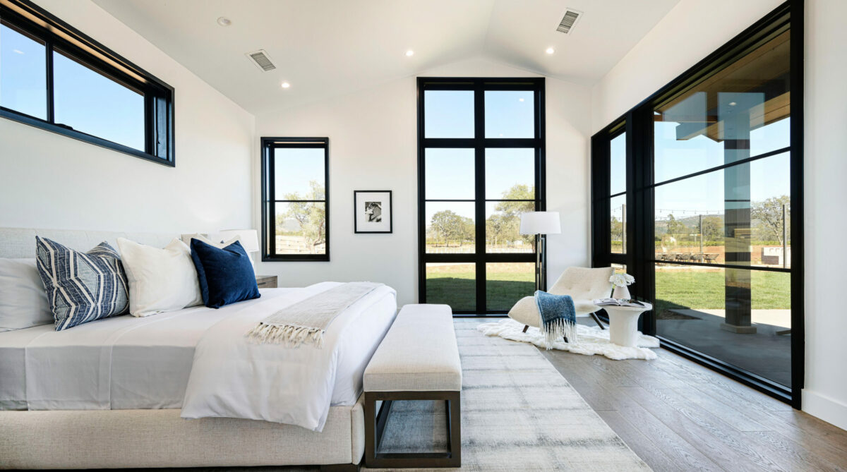 A series of windows do the design heavy lifting in this bedroom. Sparse accents of blue don't hurt either. (Robert Vente / Sotheby's International Realty)