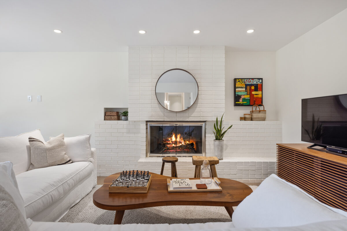 This living room has a vintage brick wood-burning fireplace. (Open Homes Photography)