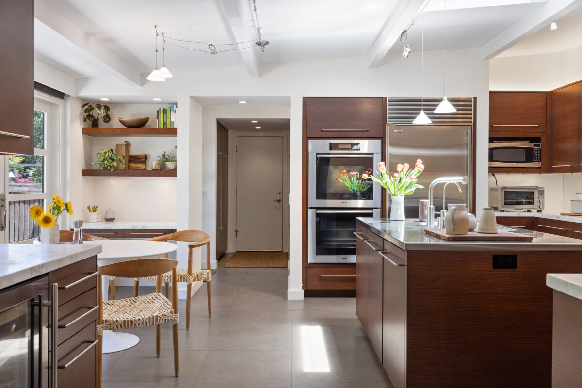 Dark wood kitchen cabinets warm up the airy look of the interior. (Open Homes Photography)