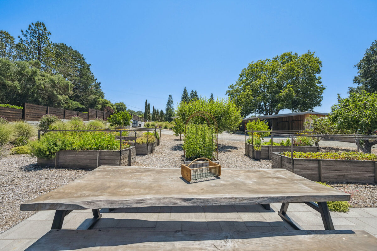 A substantially sized table allows for gathering and later noshing on the bounty from the adjacent raised beds. (Open Homes Photography)