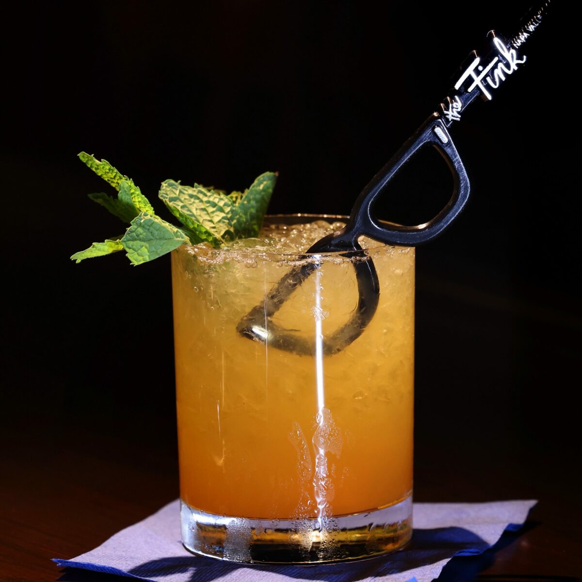 The cocktail Iuka's Grog includes dark Jamaican rum, Demerara rum, lime, pineapple and passionfruit juices, and a signature "The Fink" swizzle stick at The Fink, a new craft cocktail bar with the theme of an old boathouse in Napa, Wednesday, July 26, 2023. (Beth Schlanker / The Press Democrat)