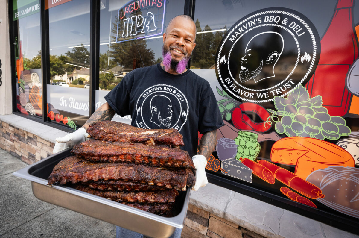 Marvin Mckinzy removes his slow-cooked tri-tip from the grill at Marvin’s BBQ and Deli Wednesday, August 30, 2023 in Sebastopol. (John Burgess/The Press Democrat)