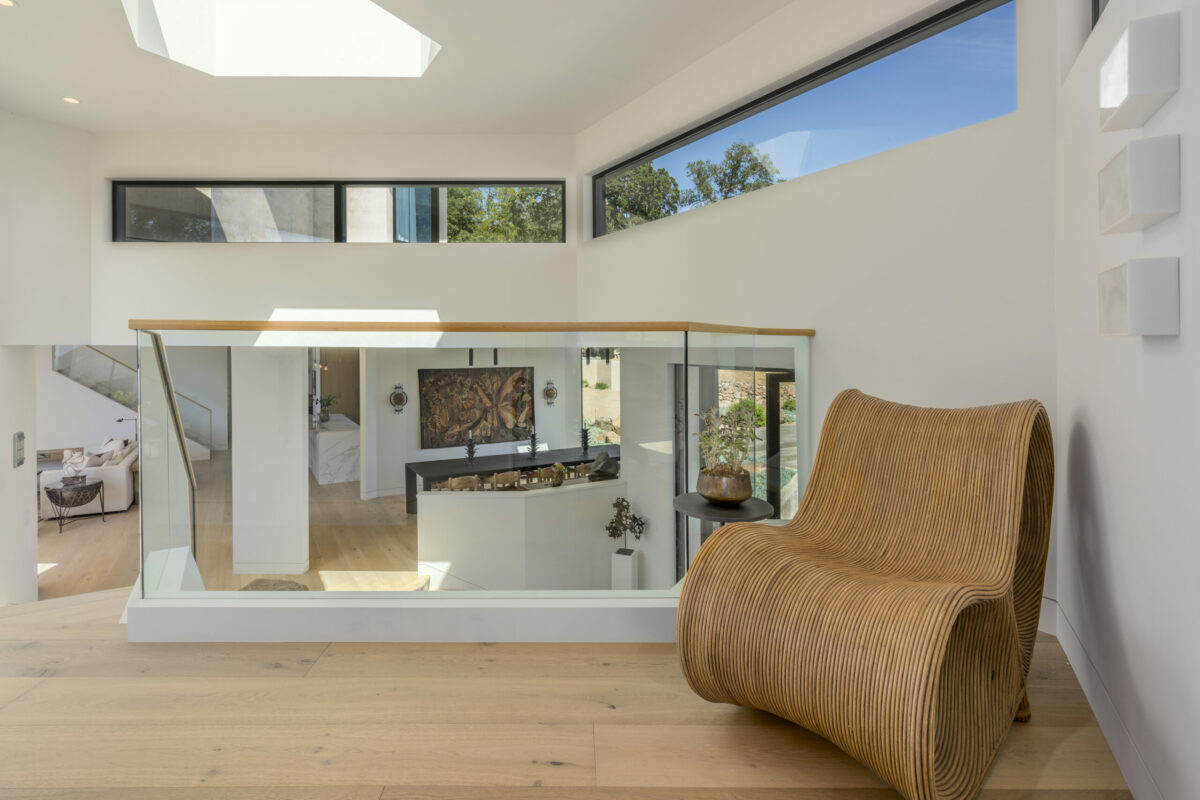 Design details, like this glass stair rail and unique chair, make the home stand out. (Provided by Caroline Sebastiani / Sotheby’s International Realty)
