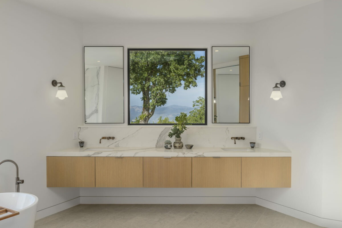In a spot that would typically hold a bathroom mirror is a window that artfully frames the view. (Provided by Caroline Sebastiani / Sotheby’s International Realty)