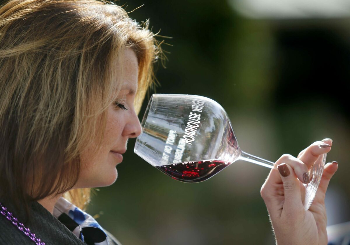 Tara Bell samples a glass of VML Moon pinot noir during the 2016 Pinot on the River Festival at the Healdsburg Plaza in Healdsburg. The event is Oct. 21 this year. (BETH SCHLANKER/ The Press Democrat)