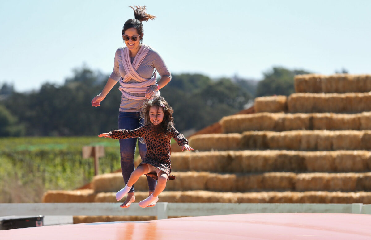Cassie Alcocer, left, bounces with Ava Alcocer-Flynn, 5, on the Jumpy Pillow at Santa Rosa Pumpkin Patch, west of Rohnert Park, on Tuesday, October 4, 2022. (Christopher Chung/The Press Democrat)
