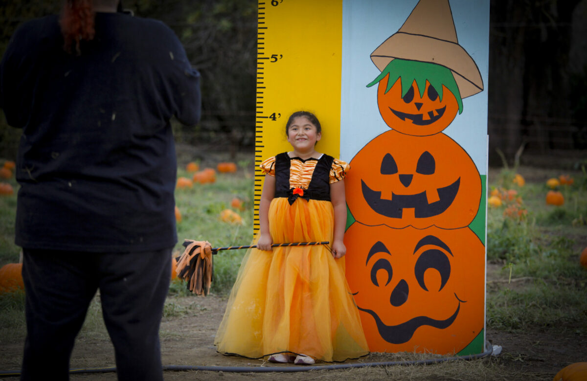 7-year-old Mia Olvera of Pinole gets her photo taken byre dad, Miguel at the Mickelson Pumpkin Patch onTuesday, October 26, 2021._Petaluma, CA, USA. (CRISSY PASCUAL/ARGUS-COURIER STAFF)