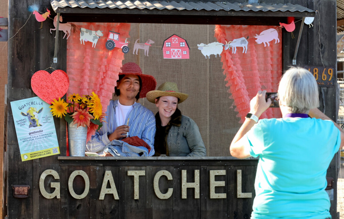 Miguel Lozano and Willow McMinn, both of Petaluma, pose in a photo booth during Goatchella, a gala fundraiser at Goatlandia animal sanctuary in Sebastopol, Sunday, Aug. 27, 2023. (Darryl Bush / For The Press Democrat)