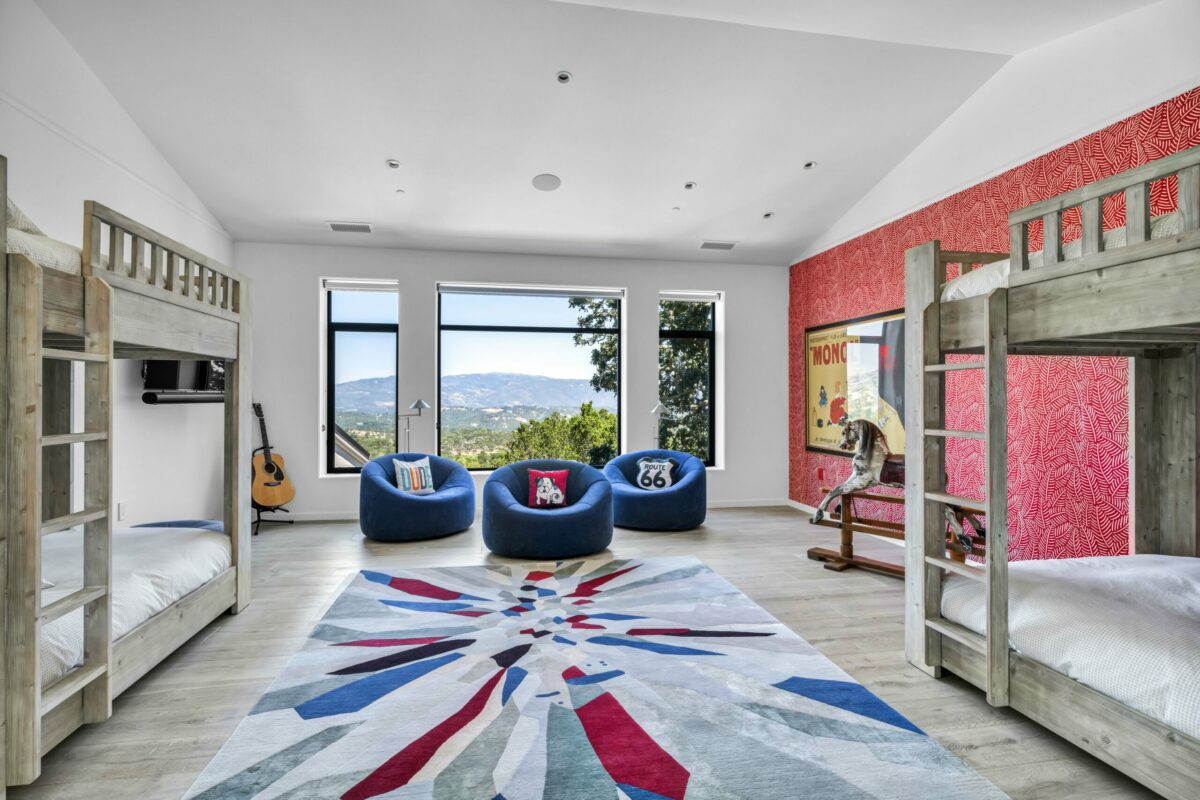 A neutral palette in this bedroom is made whimsical with textiles and primary color accents. (SeaTimber Media / Sotheby’s International Realty)