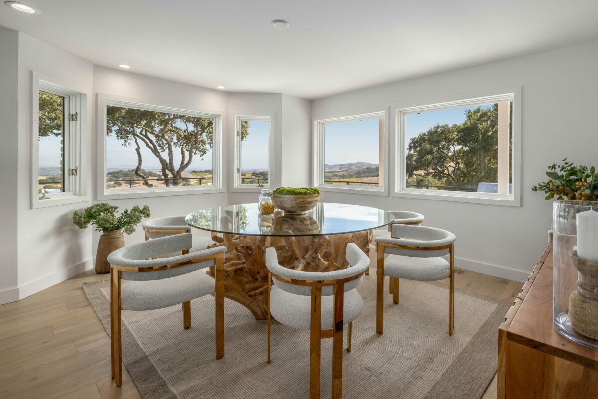 Wood accents and views of golden hills warm up the tranquil palette in this dining room. (Stephen Sugg / Sotheby’s International Realty)
