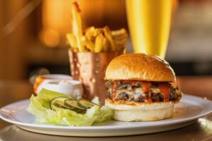The Madrona Burger with roasted onions, white Cheddar cheese, spicy ketchup and beef fat fries from the weekend brunch menu at The Madrona in Healdsburg, Friday, July 14, 2023. (John Burgess / The Press Democrat)