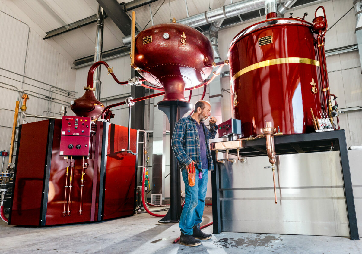 David Klein, owner of Ambix Spirits, checks the flavor of pear brandy distilling in a traditional Alambic Charentais used in Cognac and Calvados production in Europe. Klein uses the pear brandy in his Pacific Alchemy 1 blended with apple brandy. Photo taken in Sebastopol, Monday, Oct. 3, 2023. (John Burgess / The Press Democrat)