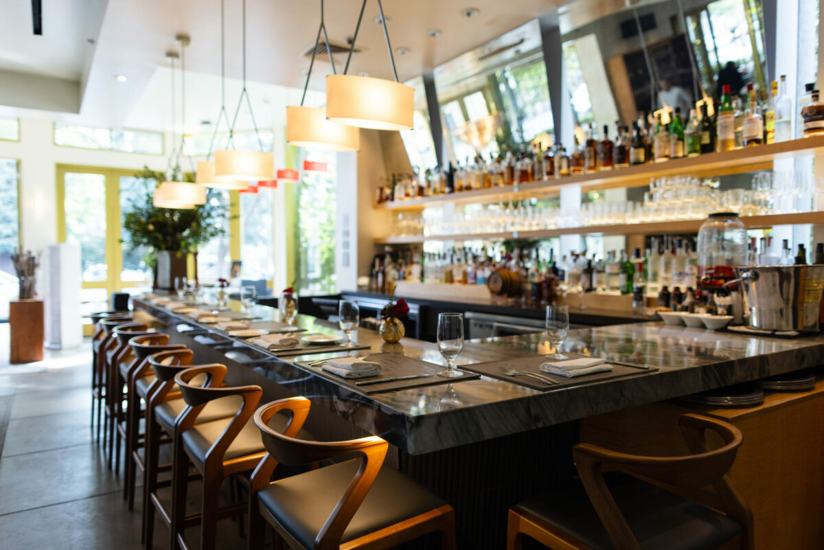 Dry Creek Kitchen’s redesigned bar in Healdsburg on Sept. 21, 2023. The new look includes a marble surface, soft lighting from overhead pendants and large mirrors behind the bar. (Paige Green)