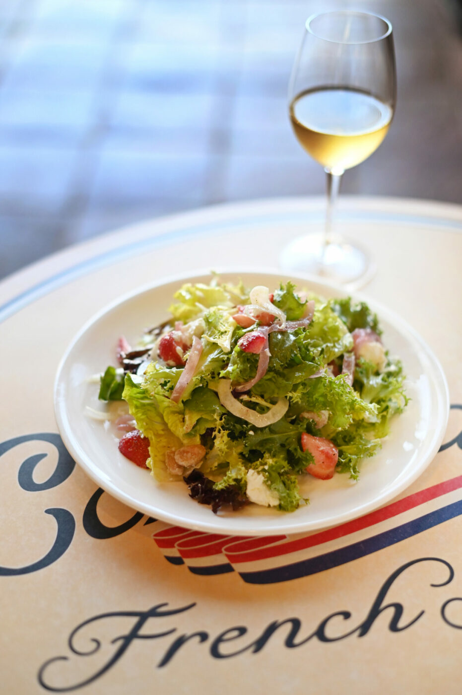 A summer salad of Russian River Farms mixed baby head lettuce, Preston Farms strawberries, shaved fennel, pickled red onions, candied almonds, Laura Chenel goat cheese and white balsamic vinaigrette on the Costeaux La Terrace bistro menu available starting at 4 p.m. Wednesday through Friday at the Costeaux French Bakery’s cafe in Healdsburg on Wednesday, July 31, 2024. (Erik Castro / For The Press Democrat)