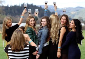 3/2/2014: B1: TOASTING WINE COUNTRY: College friends from Sonoma State University and Santa Rosa Junior College pose for a picture at Truett Hurst in the Dry Creek Valley. The annual Wine Road Barrel Tasting, which draws many young tasters, continues today and next weekend. PC: College friends from SSU and SRJC pose for a picture at Truett Hurst in the Dry Creek Valley. The 36th Annual Wine Road Barrel Tasting continues on Sunday and next weekend.